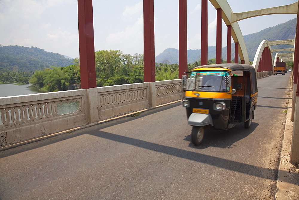 Tuk tuk crossing the Neriamangalam Bridge in Munnar, Kerala, India, Asia 