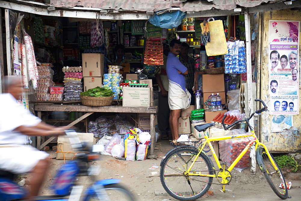 Motorcycle passing a shop in Thekkady, Kerala, India, Asia 