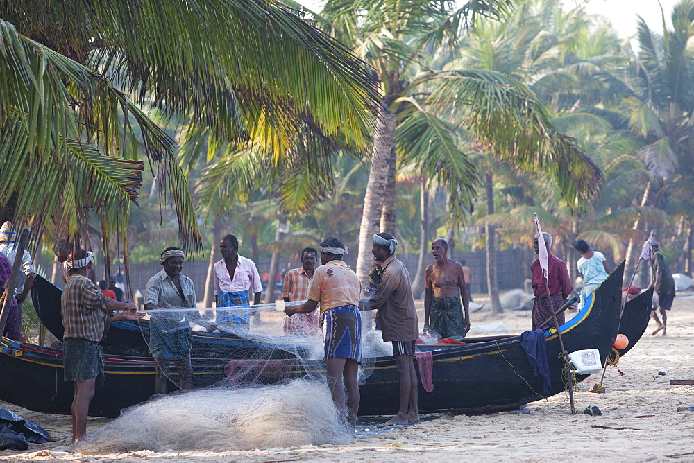 Fishermen sorting their nets at Marari Beach, Kerala, India, Asia 