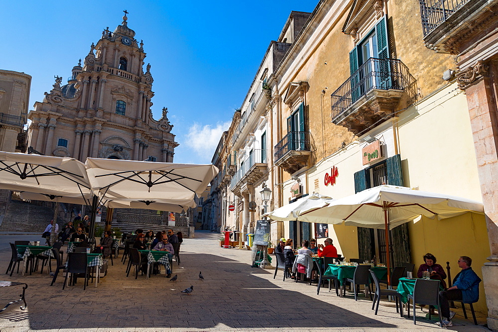 People dining in Piazza Duomo in front of Cathedral of San Giorgio in the historic hill town of Ragusa Ibla, Ragusa, UNESCO World Heritage Site, Sicily, Italy, Euruope