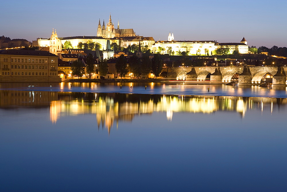 Evening reflection in River Vltava of St. Vitus's Cathedral, Royal Palace, Castle, and Charles Bridge, Prague, Czech Republic, Europe