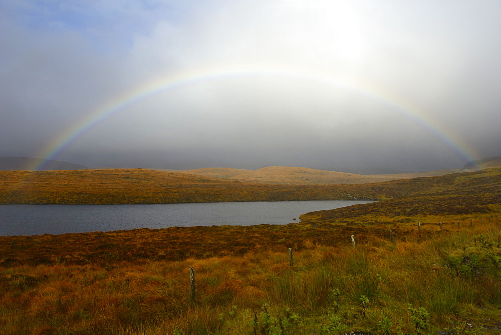 Stormy sky and rainbow over a Loch, Highlands, Scotland, United Kingdom, Europe 