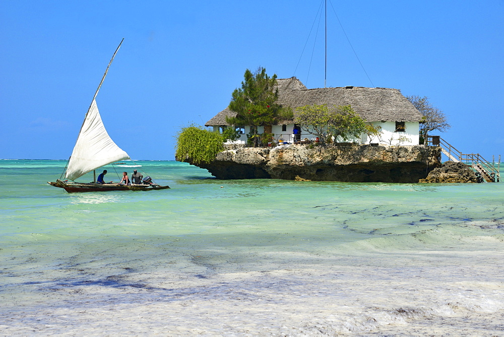 Tourist on a traditional Dhow boat, The Rock Restaurant, Bwejuu Beach, Zanzibar, Tanzania, Indian Ocean, East Africa, Africa