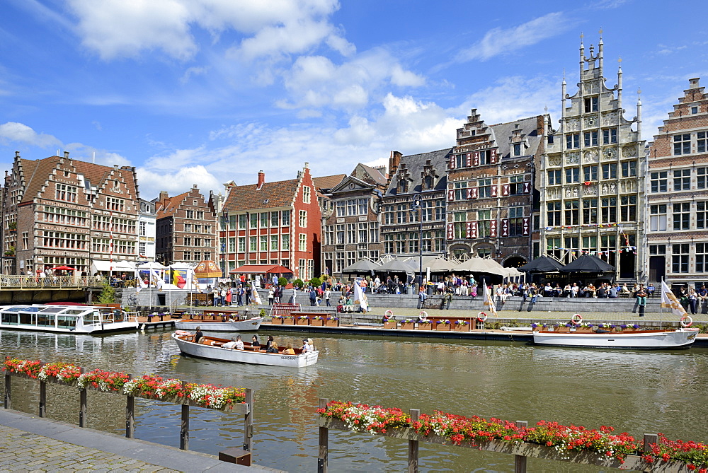 Tourists in sightseeing boats on River Leie and Medieval guild houses on Graslei Quay, Ghent, Flanders, Belgium, Europe