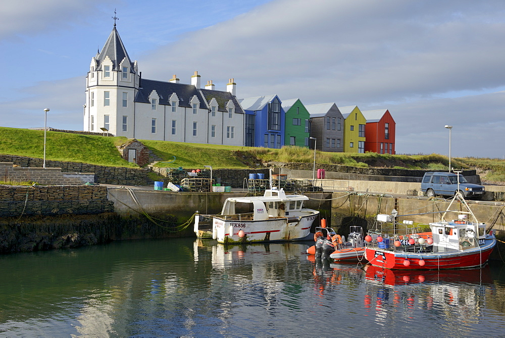 Fishing boats in the harbour and the former John O'Groats Hotel, now luxury self catering apartments, John O'Groats, Caithness, Highland Region, Scotland, United Kingdom, Europe