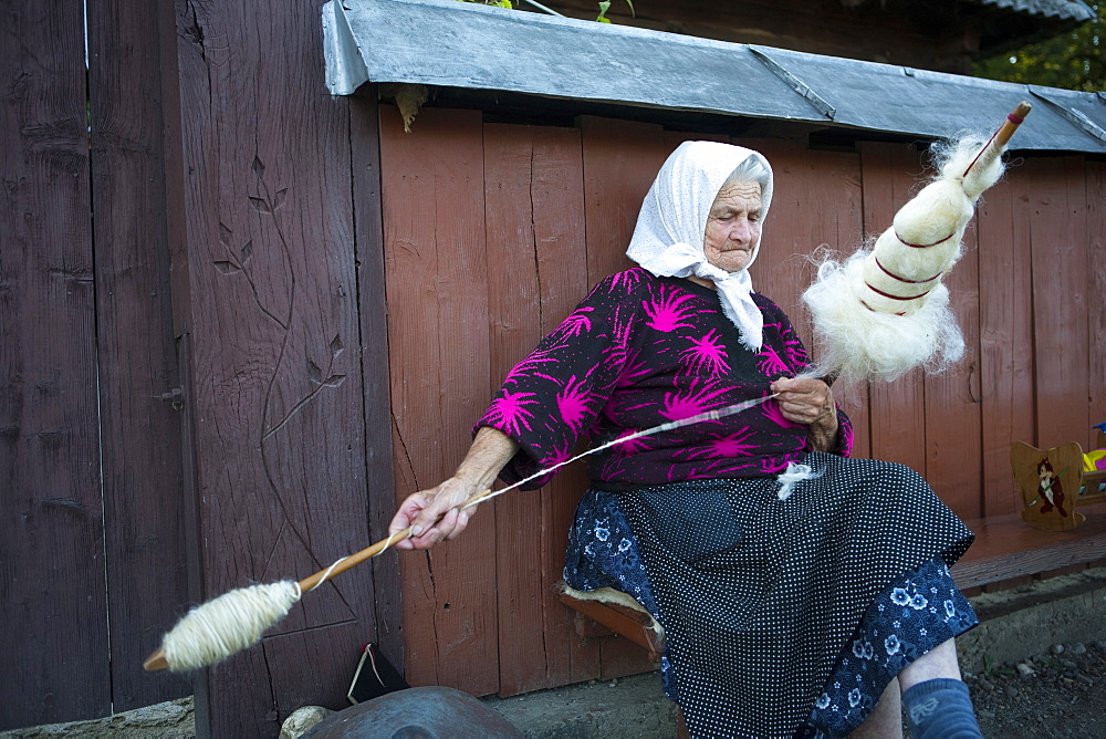 Elderly woman spinning wool, Budesti, Maramures, Romania, Europe