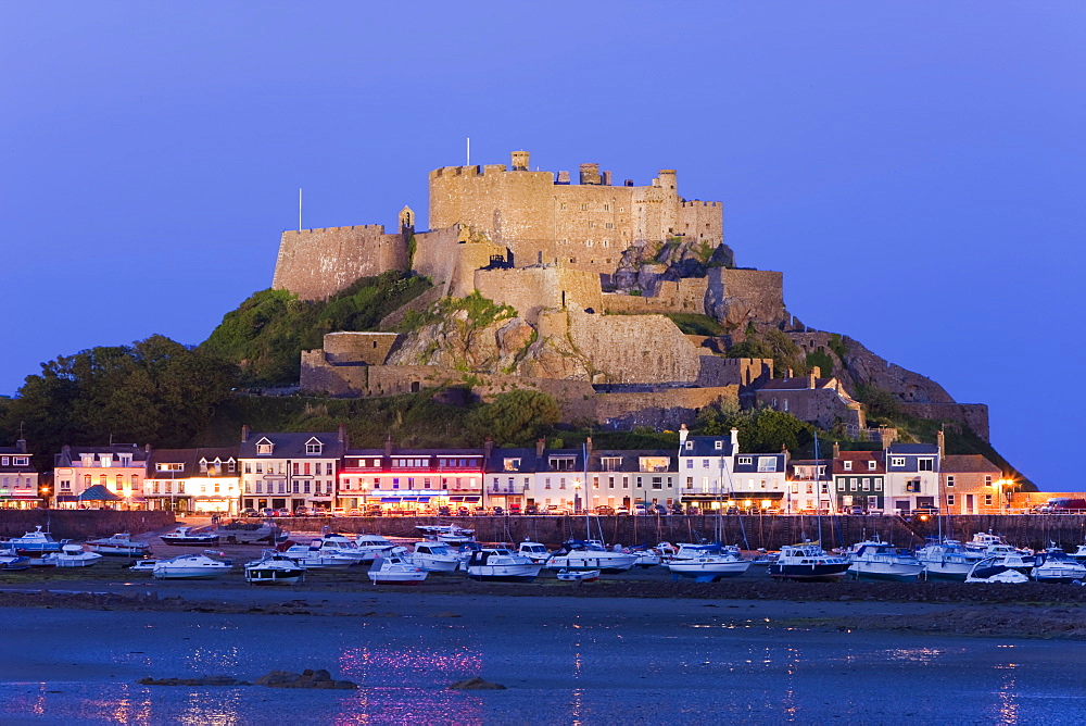 Mount Orgueil Castle, illuminated at dusk, overlooking Grouville Bay in Gorey, Jersey, Channel Islands, United Kingdom, Europe