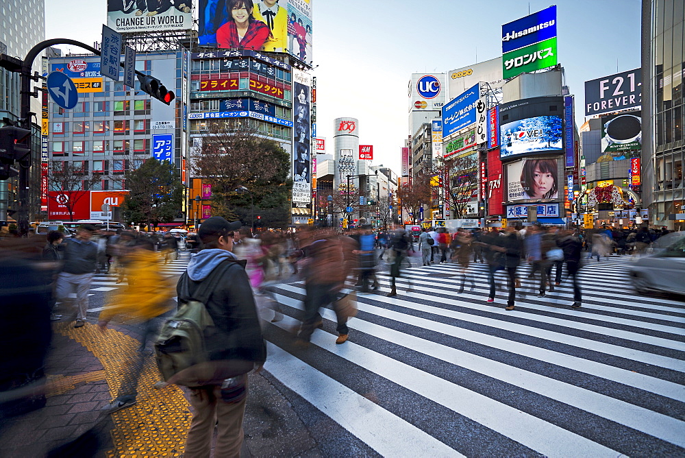 Crowds crossing the famous Shibuya Crossing intersection at the centre of Shibuya's fashionable shopping and entertainment district, Shibuya, Tokyo, Japan, Asia