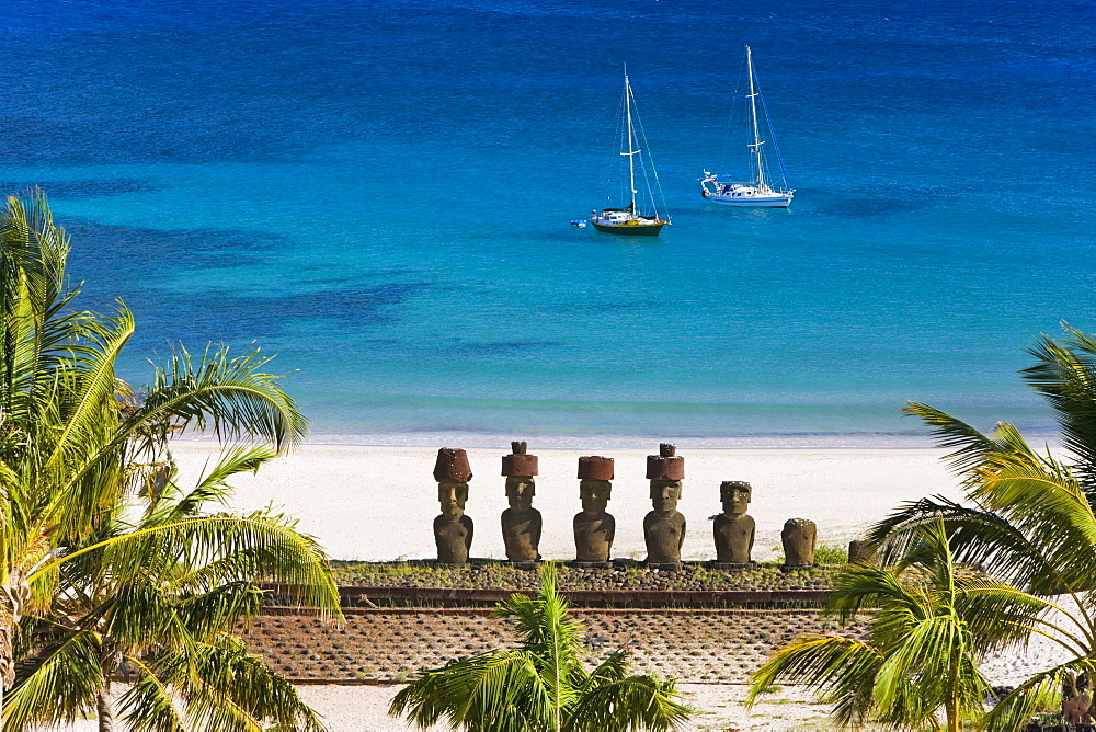 Anakena beach, yachts moored in front of the monolithic giant stone Moai statues of Ahu Nau Nau, four of which have topknots, Rapa Nui (Easter Island), UNESCO World Heritage Site, Chile, South America