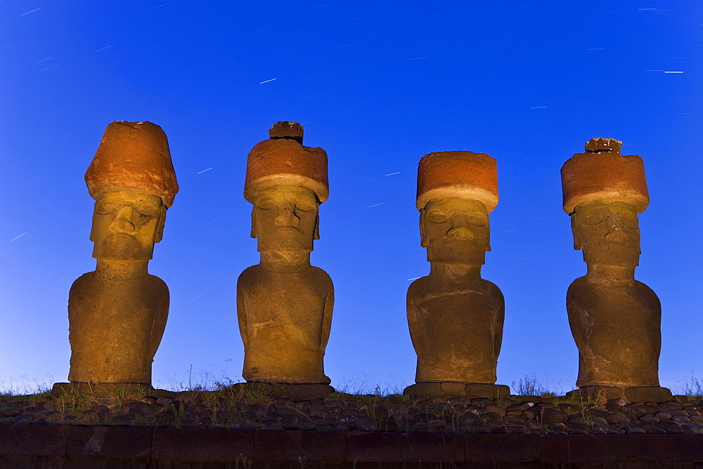 Anakena beach, monolithic giant stone Moai statues of Ahu Nau Nau, four of which have topknots, illuminated at dusk, Rapa Nui (Easter Island), UNESCO World Heritage Site, Chile, South America