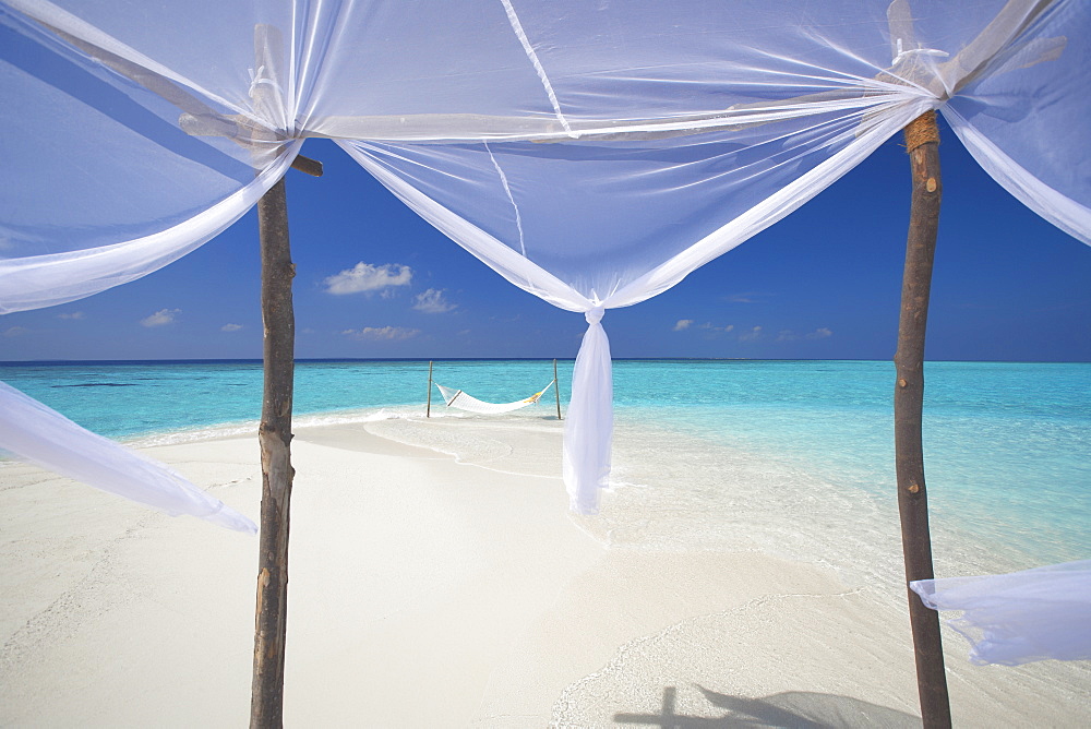 Hammock hanging in shallow clear water, The Maldives, Indian Ocean, Asia