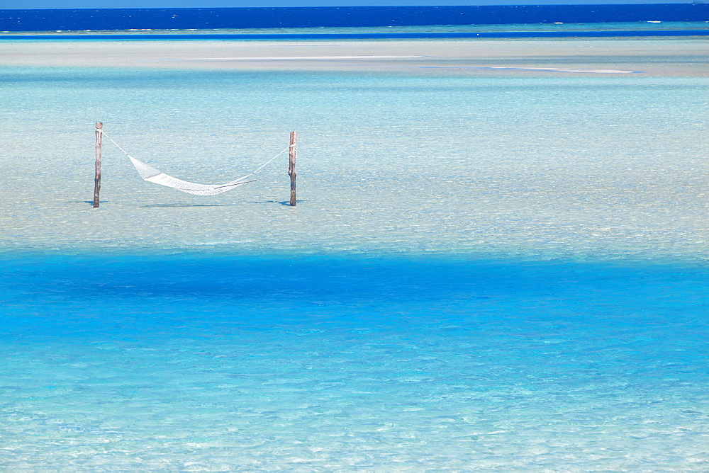 Hammock hanging in shallow clear water, Maldives, Indian Ocean, Asia