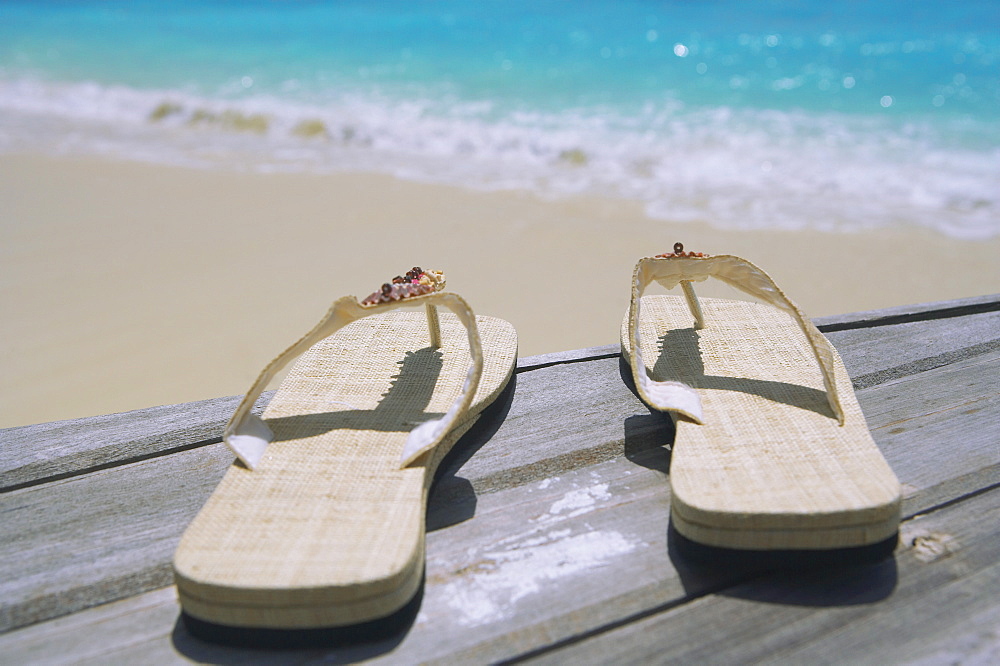 Pair of slippers on deck on beach 