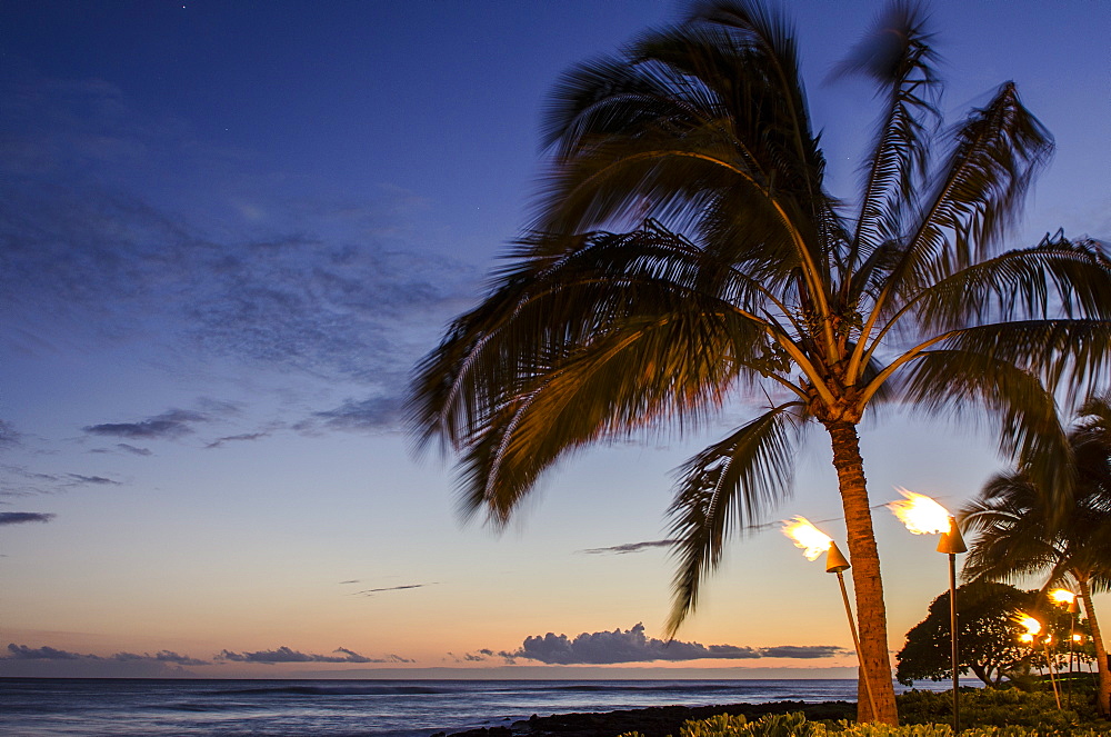 Tiki torches at sunset on Poipu Beach, Kauai, Hawaii, United States of America, Pacific