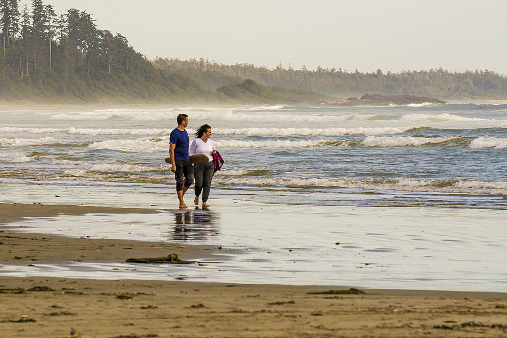 Couple beachcombing on Wickaninnish Beach, Pacific Rim National Park Reserve, Vancouver Island, British Columbia, Canada.
