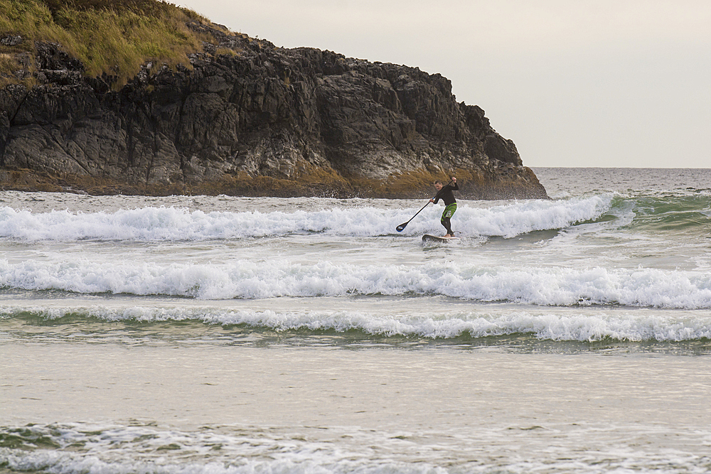 paddleboarding at Wickaninnish Beach, Pacific Rim National Park Reserve, Vancouver Island, British Columbia, Canada.