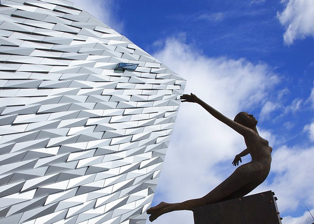 Ireland, North, Belfast, Titanic Quarter, Visitor centre designed by Civic Arts & Eric R Kuhne, with statue of diving woman in foreground.