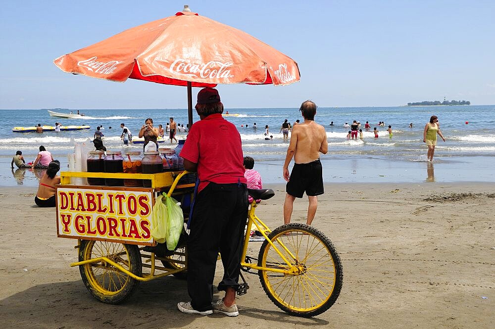 Mexico, Veracruz, Snack seller on Playa Villa del Mar with people on beach and in sea.