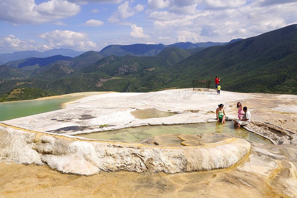 Mexico, Oaxaca, Hierve el Agua, Tourists beside limestone pools and looking out over surrounding countryside.