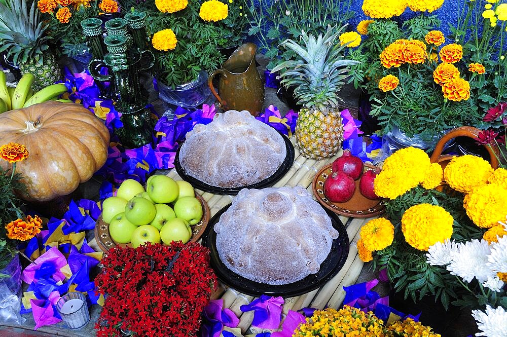 Mexico, Michoacan, Patzcuaro, Altar with display of food and flowers including marigolds for Dia de los Muertos or Day of the Dead festivities.