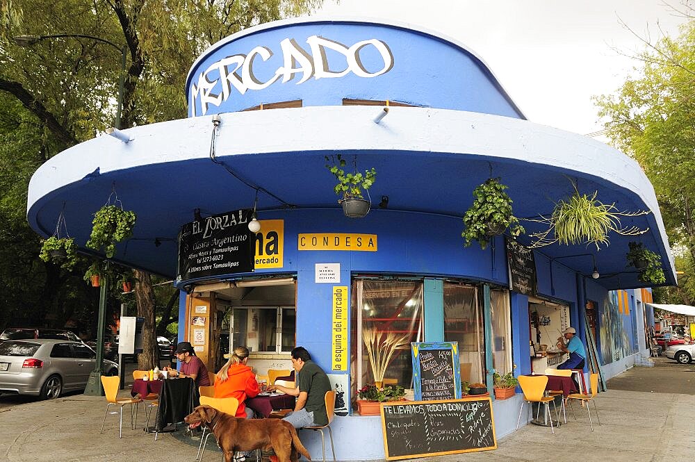 Mexico, Federal District, Mexico City, Condesa District Street restaurant blue painted exterior with customers sitting at outside tables.