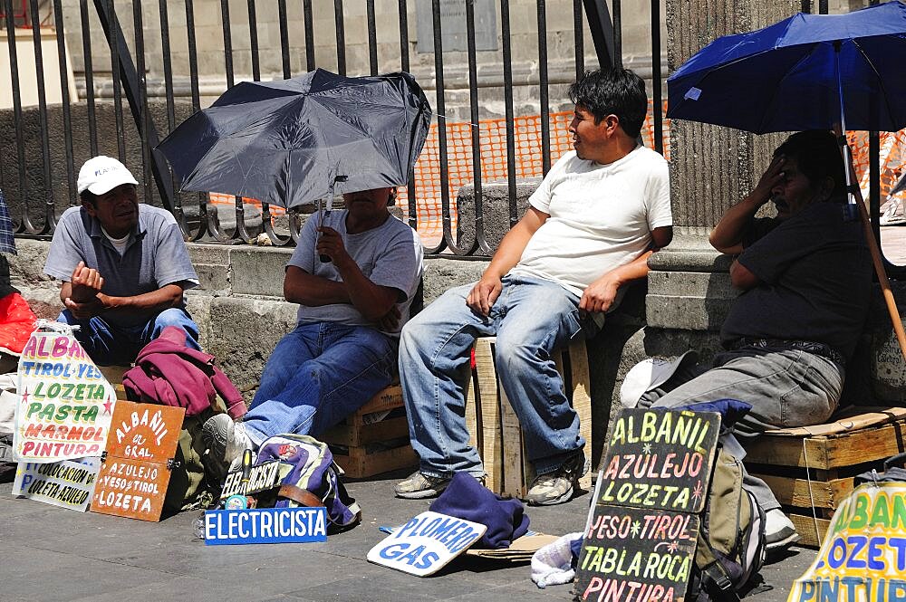 Mexico,  Federal District, Mexico City, Workers plying trade outside the Cathedral in the Zocalo using umbrellas for shade.