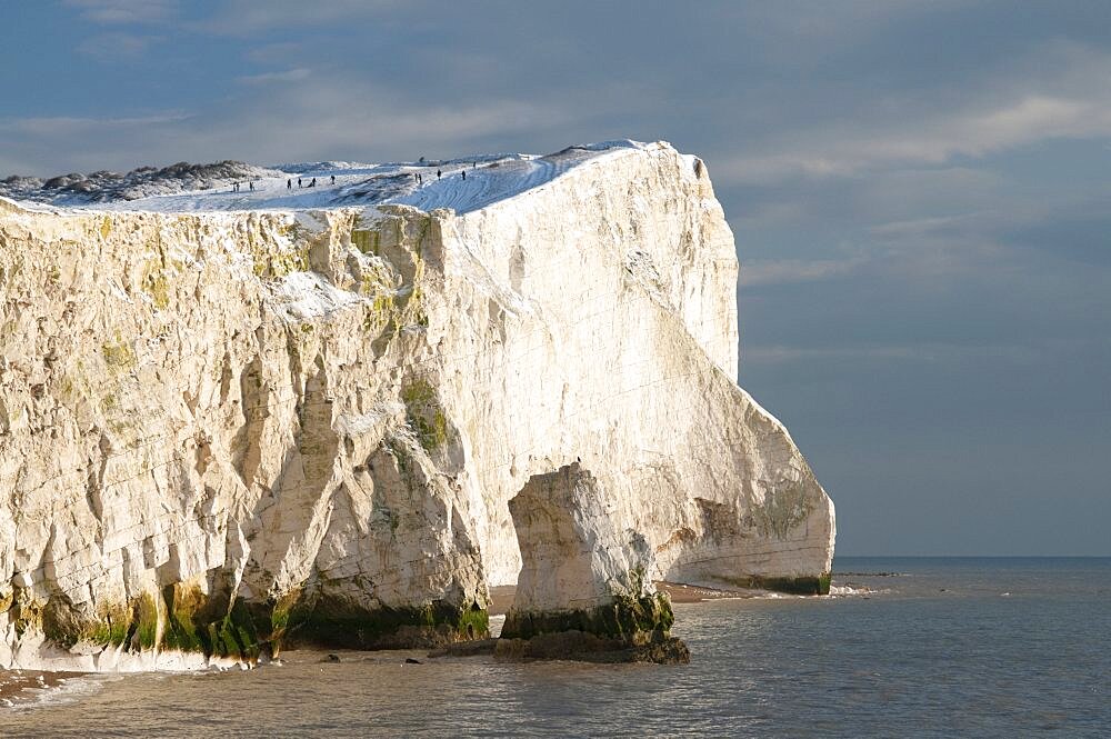 England, East Sussex, Seaford Head, Snow on cliffs with people toboganing.