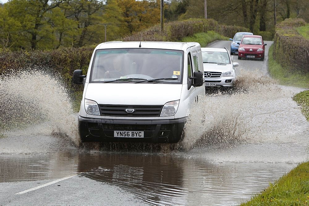 England, Kent, Flooding, Flooded country road with cars driving slowly through waters.