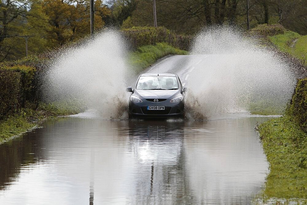 England, Kent, Flooding, Flooded country road with cars driving slowly through waters.