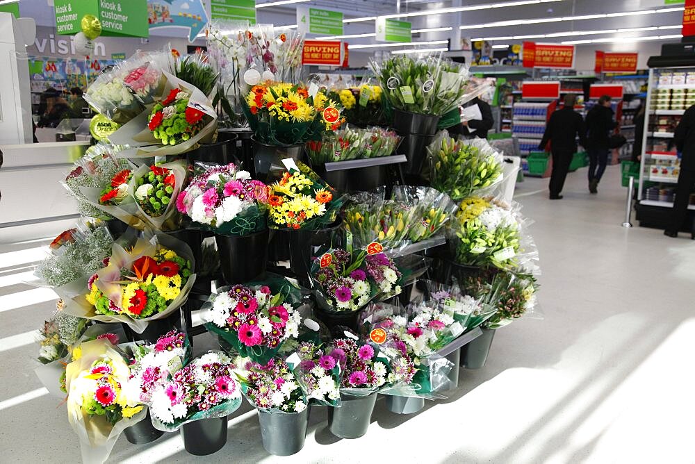 England, Shopping , Supermarket, Bunches of fresh flowers for sale by entrance.