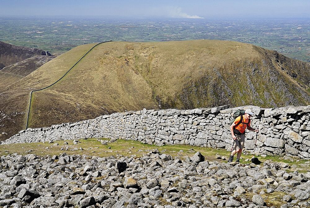 Ireland, County Down, Mourne Mountains, Hiker on Slieve Donard with Slieve Commedagh behind.