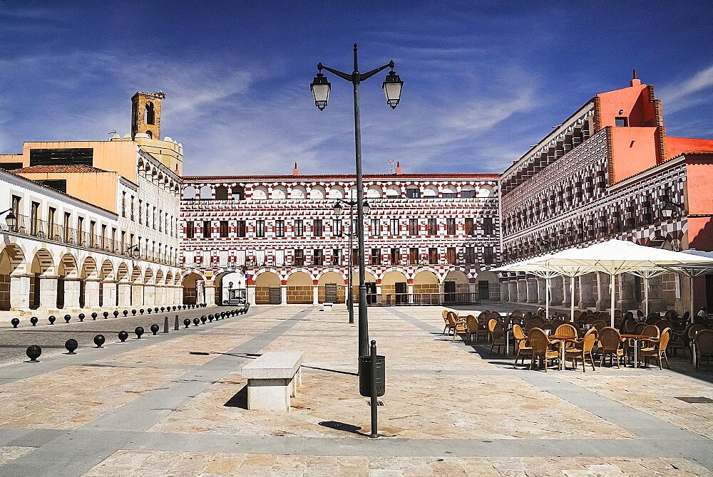 Spain, Extremadura, Badajoz, Colourfully painted buidlings in the Plaza Alta with Espantaperros tower behind.