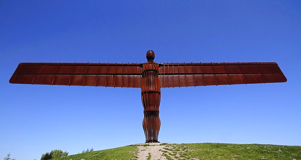 England, Tyne and Wear, Gateshead, Angel Of The North Steel Sculpture Standing 20 Metres Tall With Wingspan Of 54 Metres Constructed From Steel Designed By Antony Gormley Against A Deep Blue Sky.