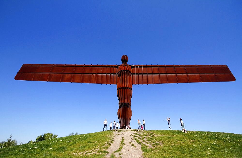 England, Tyne and Wear, Gateshead, Angel Of The North Against Deep Blue Sky Steel Sculpture By Antony Gormley Standing 20 Metres Tall With Wingspan Of 54 Metres Constructed From Steel Showing Tourists For Scale Against A Deep Blue Sky.