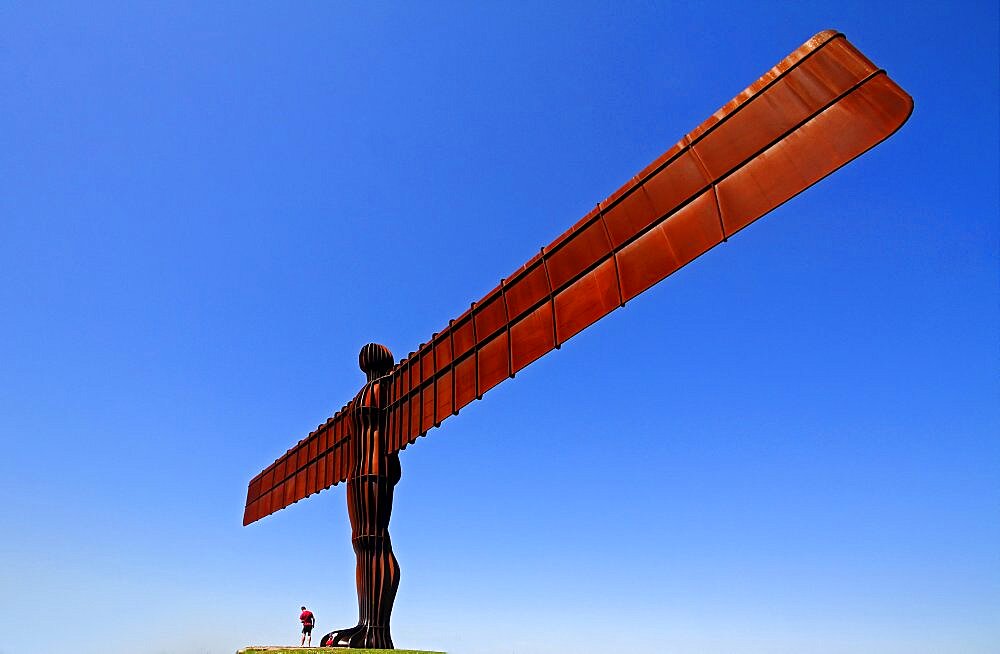 England, Tyne and Wear, Gateshead, Angel Of The North Steel Sculpture Standing 20 Metres High Designed By Antony Gormley Man Standing At Base With Child.