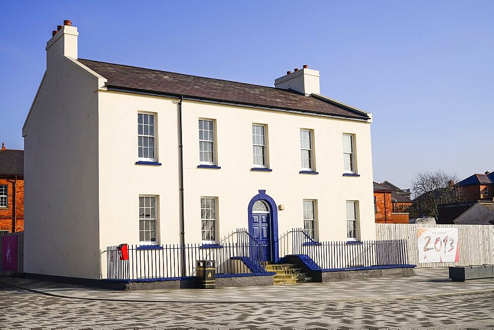 Ireland, North, Derry, Former Ebrington Barracks building with blue doorway and small Derry 2013 Year of Culture banner.