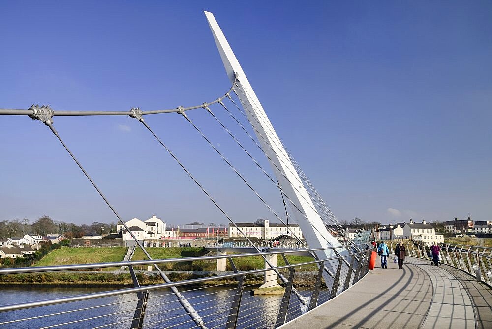 Ireland, North, Derry, The Peace Bridge over the River Foyle opened in 2011 with the former Ebrington Barracks in the background.