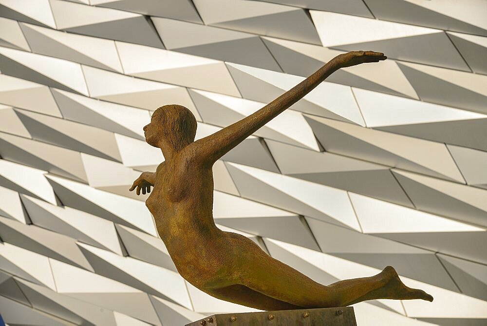 Ireland, North, Belfast, Titanic Quarter, Titanic Belfast Visitor Experience, 'Titanica' sculpture by Rowan Gillespie with section of the building in the background.