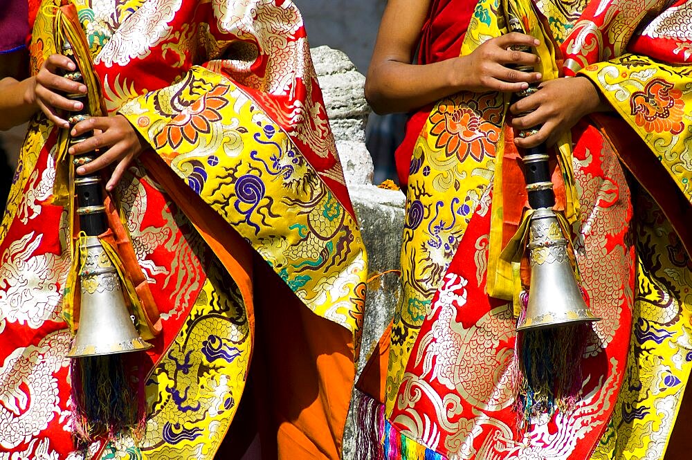 Bhutan, Bumthang District, Tamshing Lhakang, Buddhist pipe players dressed in ceremonial silk robes.