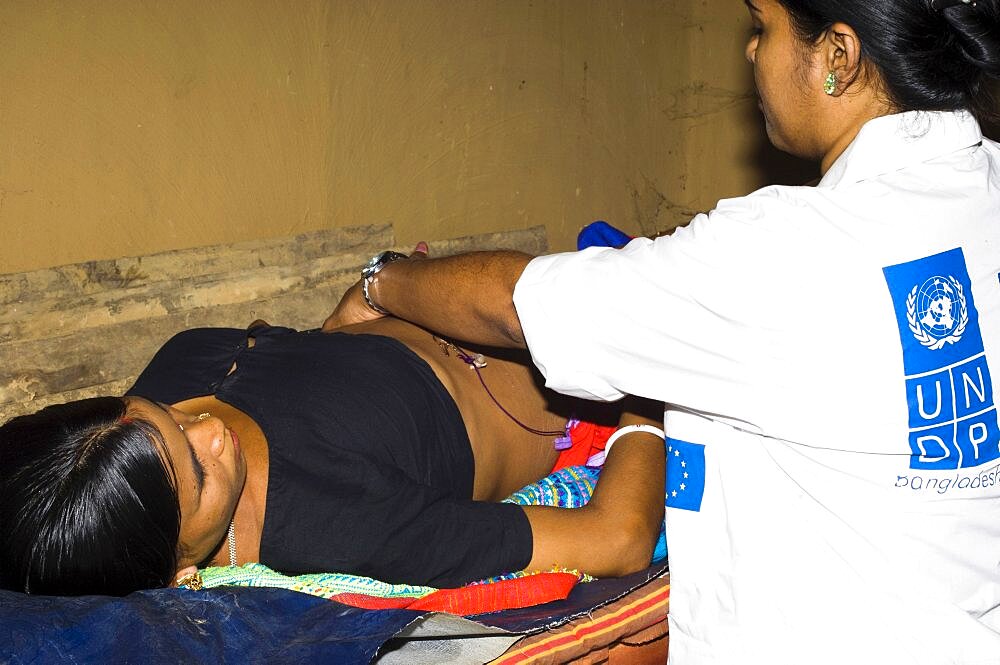 Bangladesh, Chittagong Division, Khagrachari, Pregnant mother being examined by UNDP nurse.