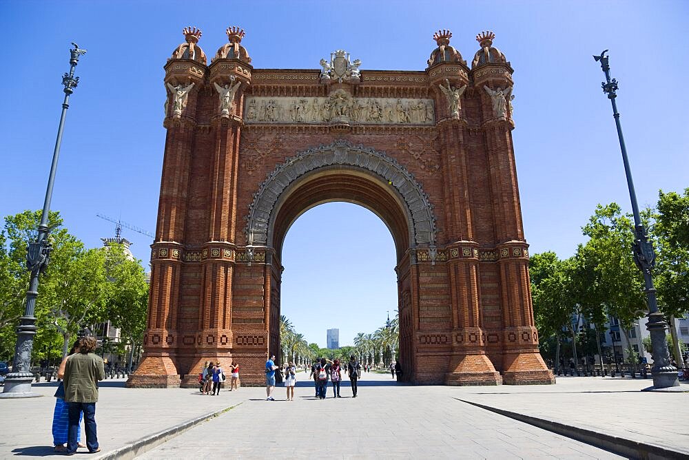 Spain, Catalonia, Barcelona, Sightseers at the Arc del Triomf built for the 1888 Universal Exhibition designed by Josep Vilaseca in the Mudejar Spanish Moorish style as the main gateway into the Parc de la Ciutadella in the Old Town district.,