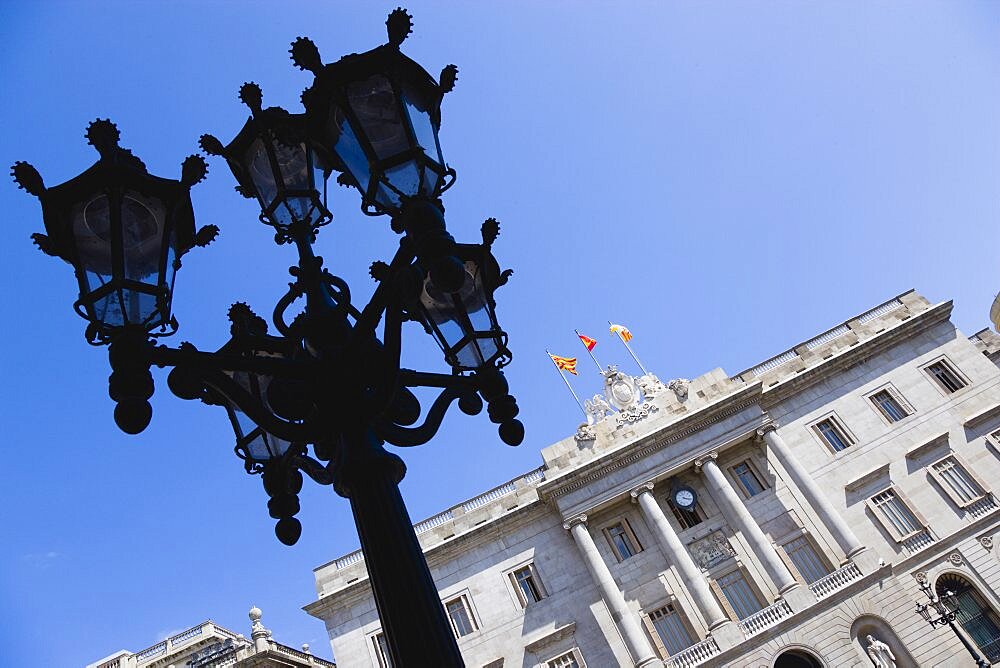 Spain, Catalonia, Barcelona, The Neo-Classical town hall Casa de la Ciutat in Placa de Sant Jaume in the Gothic Quarter with an ornate street light in the foreground.