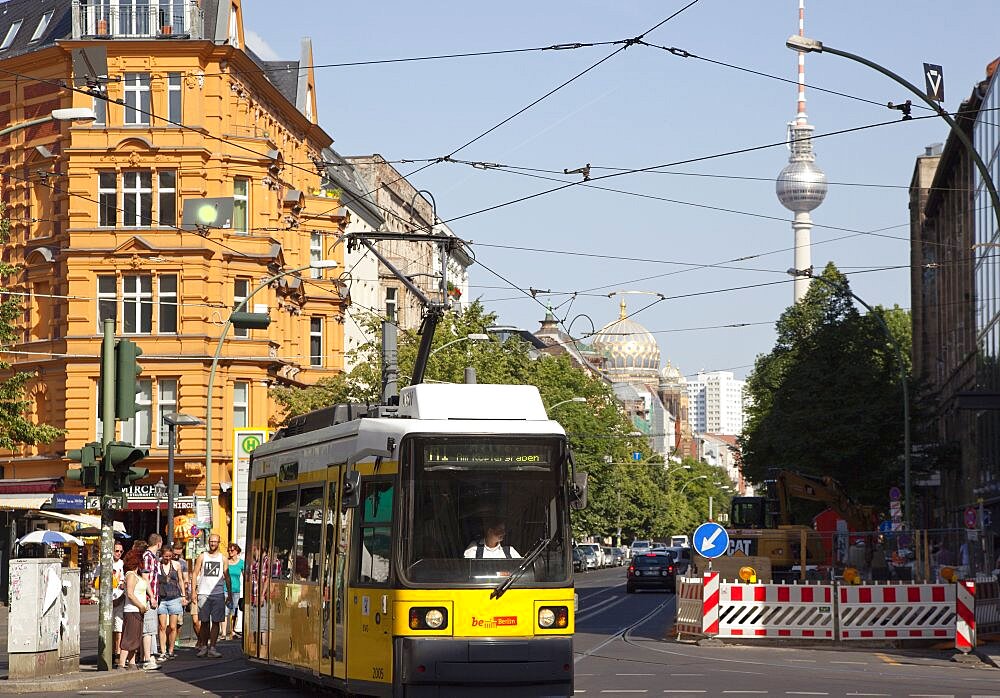 Germany, Berlin, Mitte, tram exiting Oranienburger Strasse with the Neue Synagogue and TV tower behind.