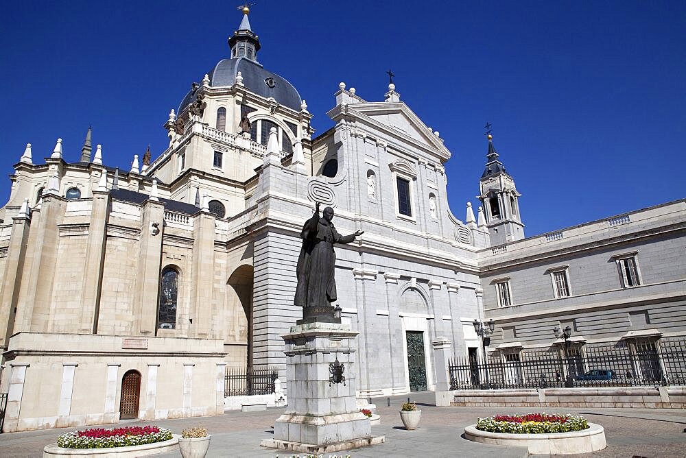 Spain, Madrid, Cathedral de la Almudena with statue of Pope John Paul II in the courtyard.