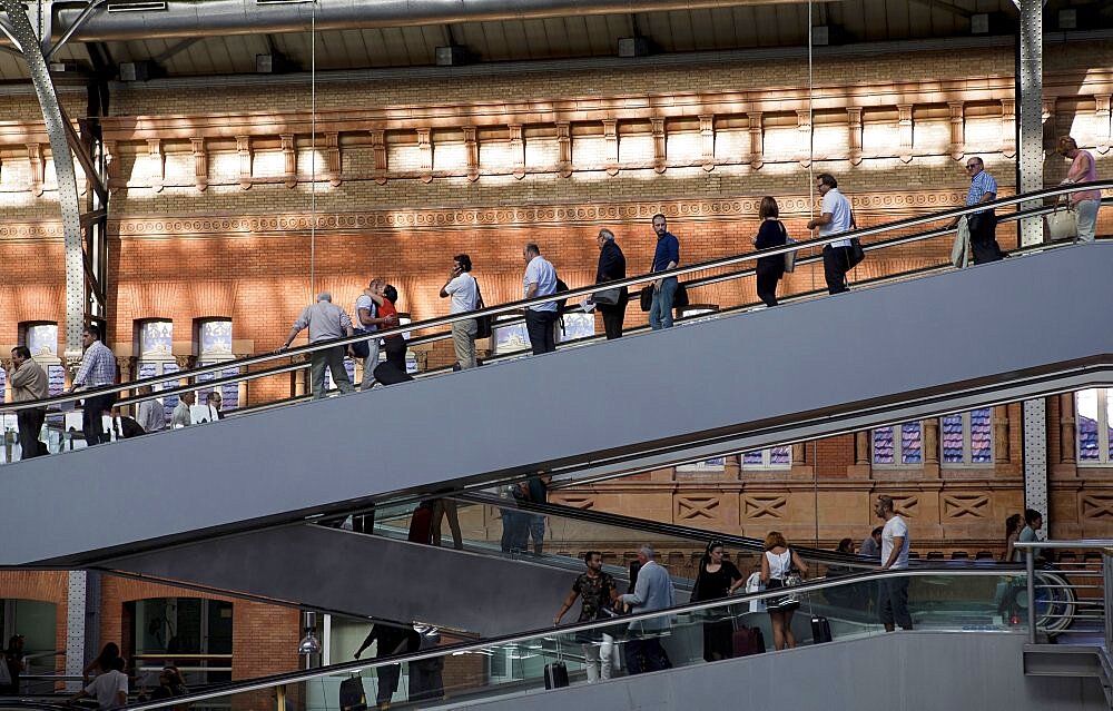 Spain, Madrid, Passengers using the escalators inside the terminus of the Atocha Railway Station.