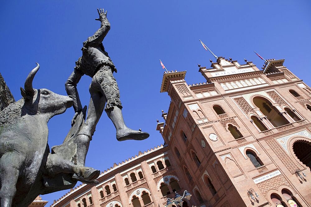 Spain, Madrid, Statue of a matador with the Plaza de Toros de las Ventas in the background.