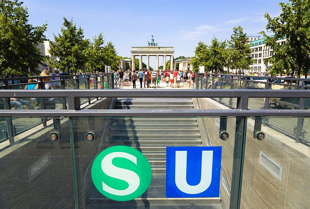 Germany, Berlin, Mitte, sightseeing tourists emerging from the U-Bahn and S-Bahn station on Unter den Linden and walking towards Brandenburg Gate or Brandenburger Tor.