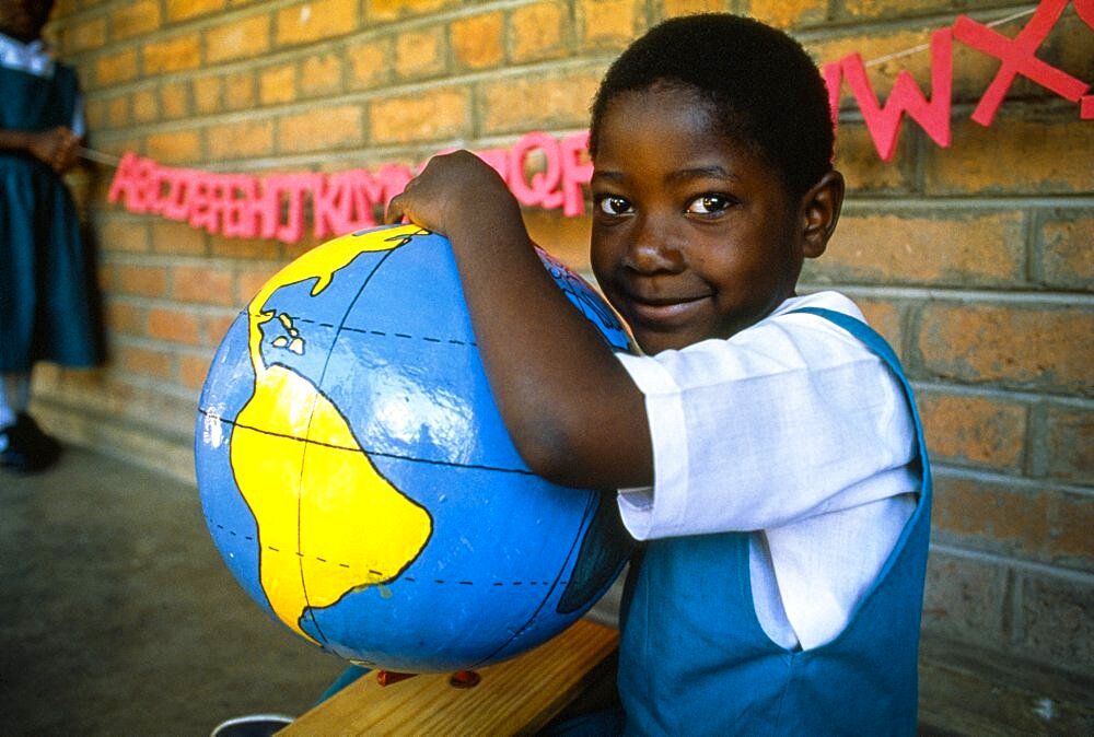 MALAWI  Blantyre Schoolgirl with papier mache globe teaching aid made by PAMET who recycle everything from newspapers to elephant dung