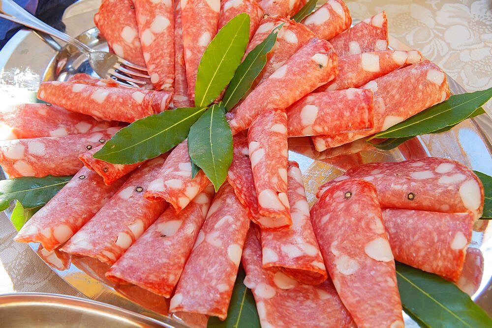 Italy, Tuscany, Lucca, Barga, Display of sliced meat as part of a buffet to be eaten with aperitifs.