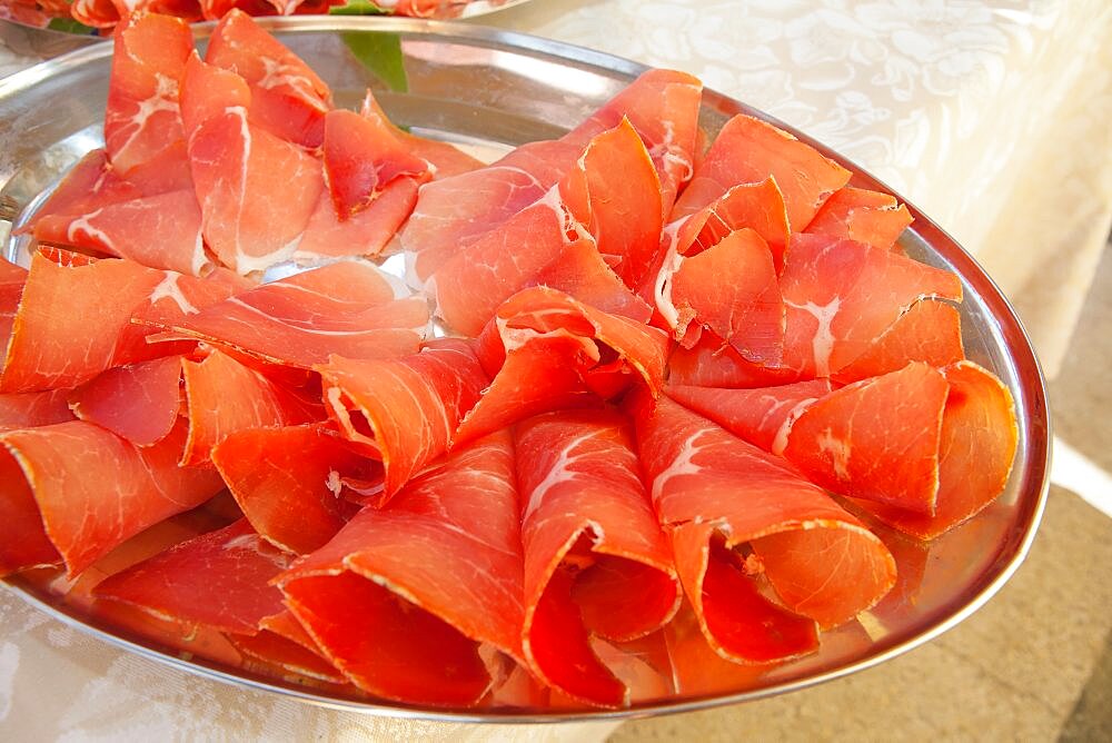 Italy, Tuscany, Lucca, Barga, Display of sliced meat as part of a buffet to be eaten with aperitifs.